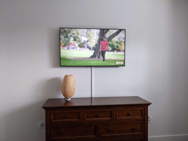 Master bedroom TV mounting with external cord masking.